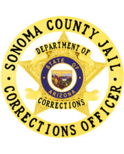 Corrections Officer gold badge with star in the middle and circle around it. a gold star with blue and yellow text