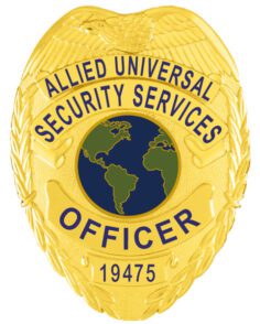 A detailed view of a custom metal badge in gold color, emphasizing its unique shield shape and intricate engravings, including the phrase “security services,” designed with a practical safety pin attachment for dependable use on uniforms