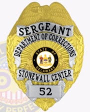 A detailed gold badge for a Sergeant of Corrections, featuring the inscription 'DEPARTMENT OF CORRECTIONS' prominently displayed. The badge showcases the state seal of Delaware at its center, surrounded by the words 'STONEWALL CENTER' in a bold ribbon. The design includes an eagle emblem at the top, symbolizing authority. This badge is an excellent representation of corrections badges for correctional officers, highlighting professionalism and dedication to service.
