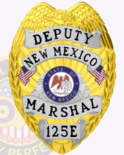 A vibrant gold badge for a Deputy Marshal from New Mexico, featuring an eagle emblem at the top. The badge prominently displays 'DEPUTY' and 'NEW MEXICO' in bold lettering on silver ribbons. At the center, the state seal of New Mexico is surrounded by the word 'MARSHAL' and the badge number '125E.' This badge exemplifies authority and service, making it an excellent representation of US Marshals badges for federal agencies.