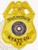 Close-up view of a custom metal badge in gold color with a safety pin attachment, showcasing "WYATT CO. TX" along with the unique identifier "658742." The intricate details include the Texas state seal, emphasizing authority and professionalism in private investigations.