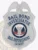 A polished image of a custom metal badge in silver color, featuring a shield design with the inscription “Bail Bond Investigator” and “Bail Enforcement,” complete with a central emblem and a safety pin attachment for secure wear.