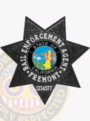 An engaging representation of a custom metal badge in black color, exhibiting an elegant design with the name “Fremont” in the center and the title “Bail Enforcement Agent,” designed with a safety pin attachment for effortless integration into attire.