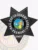 An engaging representation of a custom metal badge in black color, exhibiting an elegant design with the name “Fremont” in the center and the title “Bail Enforcement Agent,” designed with a safety pin attachment for effortless integration into attire.