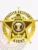 An eye-catching image of a custom metal badge in gold color, showcasing a five-pointed star design adorned with the words “Fugitive Recovery” and “Agent,” equipped with a safety pin attachment for easy fastening to clothing.
