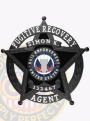 A polished visual of a custom metal badge in black color, exhibiting an elegant star design with prominent text stating “Fugitive Recovery,” designed with a practical safety pin attachment for dependable use on clothing.