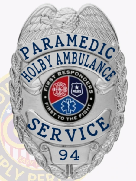 A sleek custom metal badge in silver color featuring "PARAMEDIC" and "HOLBY AMBULANCE" prominently displayed, equipped with a safety pin attachment for secure wear by emergency responders.