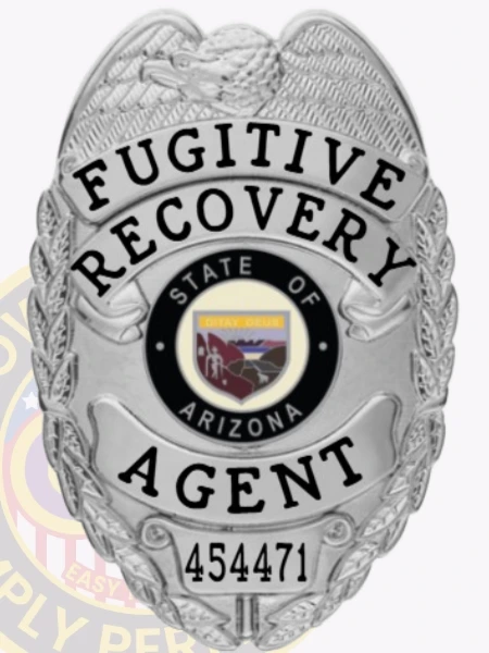 A polished image of a custom metal badge in silver color, featuring an eagle-adorned design with the inscription “Fugitive Recovery” and “Agent,” along with a central emblem representing the State of Arizona, complete with a safety pin attachment for secure wear.