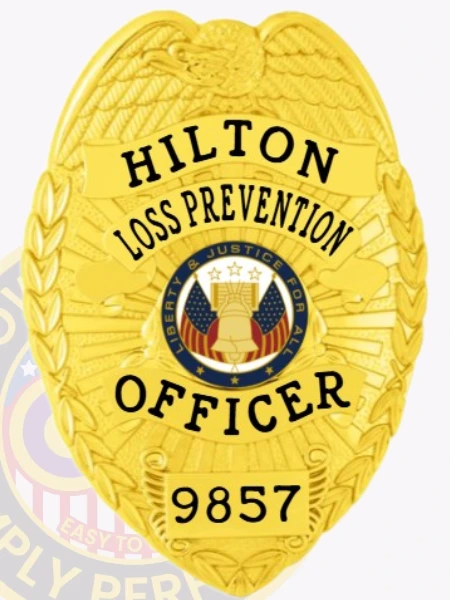 This elegant custom metal badge in gold color showcases the inscription "HILTON LOSS PREVENTION OFFICER" in bold lettering, highlighted by a central emblem representing justice and protection. The badge also displays the identifier 9857 and features a safety pin attachment for easy wear.