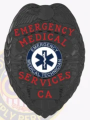 A distinctive custom metal badge in black color with a safety pin attachment designed for emergency medical services personnel. The badge prominently features "EMERGENCY MEDICAL SERVICES," alongside the star of life and "CA," showcasing dedication to providing critical care and support during emergencies.