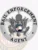An artistic portrayal of a custom metal badge in silver color with a safety pin attachment, prominently featuring "BAIL ENFORCEMENT AGENT." The badge incorporates an eagle design and intricate details, illustrating its essential role for bail enforcement agents.