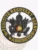 A captivating visual of a custom metal badge in black color, emphasizing detailed engravings of an eagle and the phrase “Fugitive Recovery Agent” in yellow, featuring a sturdy safety pin attachment for dependable use on uniforms.