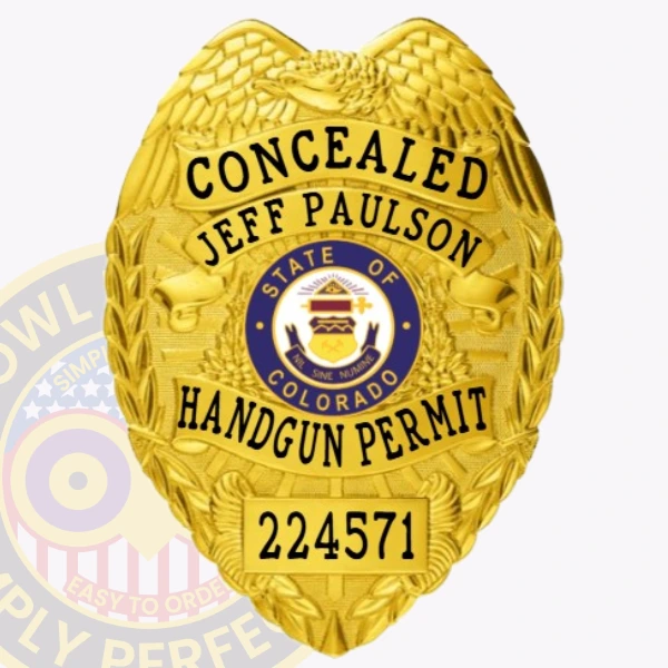 Highlighted is a custom metal badge in an eye-catching gold finish, featuring the State of Colorado emblem and the inscription "HANDGUN PERMIT." The reliable safety pin attachment makes this badge ideal for those who require a stylish and functional identification solution.