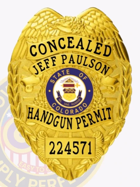 Highlighted is a custom metal badge in an eye-catching gold finish, featuring the State of Colorado emblem and the inscription "HANDGUN PERMIT." The reliable safety pin attachment makes this badge ideal for those who require a stylish and functional identification solution.