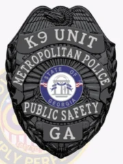 This striking custom metal badge in black color showcases a detailed shield design with "K9 UNIT" and "METROPOLITAN POLICE" inscribed at the top. The central emblem highlights the state seal of Georgia, complemented by "PUBLIC SAFETY" and "GA," and features a safety pin attachment for practical wear.