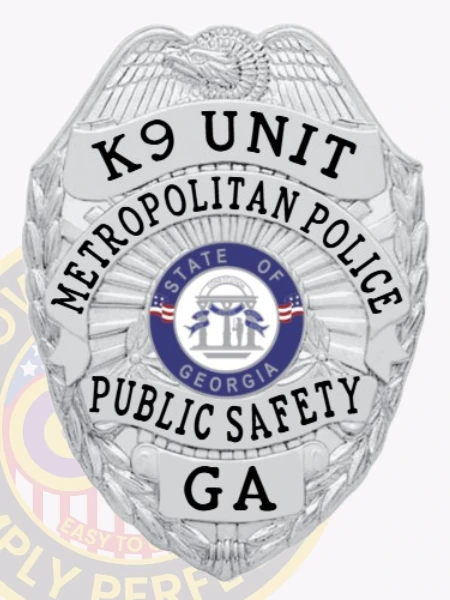 A sleek custom metal badge in silver color shaped like a shield. The badge prominently features "K9 UNIT" and "METROPOLITAN POLICE" at the top, with the center displaying the emblem for the state of Georgia, surrounded by "PUBLIC SAFETY" and "GA." It includes a safety pin attachment for secure fastening on uniforms.