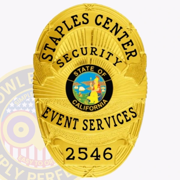 An eye-catching custom metal badge in gold color, adorned with "STAPLES CENTER SECURITY" prominently displayed above a round emblem that represents the state of California. The badge features the unique identification number, 2546, and comes with a safety pin attachment for secure placement.