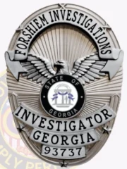 Close-up view of a custom metal badge in silver color with a safety pin attachment, highlighting "INVESTIGATOR GEORGIA 93737." The intricate details include an eagle motif and the state seal, emphasizing authority and expertise in investigative work.