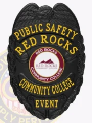 Featuring a polished custom metal badge in black color with a safety pin attachment, this badge reads "PUBLIC SAFETY RED ROCKS." The eye-catching design includes the Red Rocks Community College logo in the center, symbolizing authority and commitment to safety.