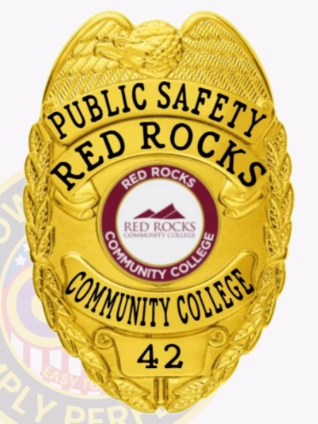 This custom metal badge in gold color with safety pin attachment showcases a detailed design, featuring the inscription "PUBLIC SAFETY RED ROCKS" at the top and an emblem at the center representing Red Rocks Community College. The badge highlights its shiny gold finish and intricate details, perfect for identification.