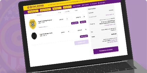 A laptop screen displaying the Owl Badges website featuring Custom EMT Badges and Emergency Medical Technician Badges available for purchase. The webpage includes badge images, detailed descriptions, and pricing options, guiding users on when to buy custom EMS badges for official use. The vibrant purple and yellow design enhances the user-friendly shopping experience for medical professionals