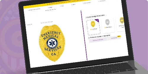 A laptop screen displaying an online customization tool for designing custom EMT badges and Emergency Medical Technician badges. The featured badge is a polished gold oval design, prominently displaying the text 'Emergency Medical Services' in bold blue lettering, along with a recognizable star of life emblem in the center. Below the emblem, 'CA' indicates the state designation. On the right side of the interface, users can select badge colors, including options like silver and black, and customize additional features. This image effectively illustrates where to buy custom EMT badges, emergency medical technician badges, and EMS badges through an intuitive online platform.
