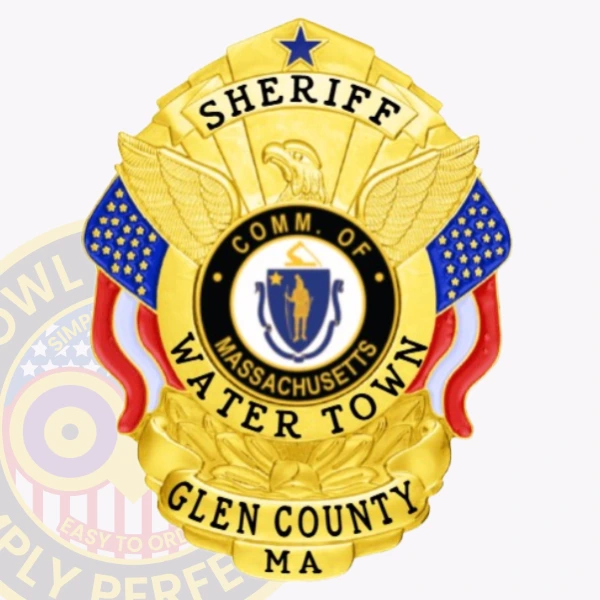 A custom metal badge in gold displaying the title "SHERIFF" prominently at the top, with a central eagle emblem above the words "COMM. OF MASSACHUSETTS." The center features a circular state seal, surrounded by the text "WATER TOWN" and "GLEN COUNTY MA." The badge is adorned with decorative elements in blue and red, enhancing its vibrant appearance. The polished gold finish emphasizes its official status and significance in law enforcement, showcasing its importance in the community.