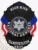 This striking custom metal badge in black color includes a safety pin attachment and showcases the word "HIGH RISK" prominently at the top. The central eagle motif is surrounded by "NATIONAL ARMORED TRANSPORTATION," framed by bold red and blue elements, emphasizing its significance in high-security contexts.