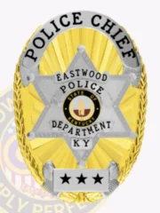 Eastwood police chief custom gold oval metal badge featuring a polished gold background with sunburst texture, highlighted by a silver six-point star containing the colorful Kentucky state emblem, silver scroll with black text POLICE CHIEF across the top edge, EASTWOOD POLICE DEPARTMENT inscribed inside the star, and three black stars on a silver plate near the bottom; safety pin attached.