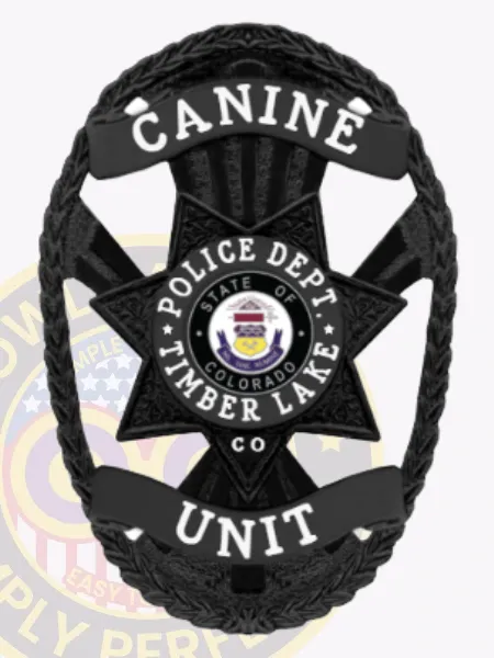 This elegant custom metal badge in black showcases a distinctive star shape adorned with detailed etching. The word "CANINE" is prominently featured at the top in white letters. In the center, the badge displays the Timber Lake Police Department logo, encircled by "POLICE DEPT." and "STATE OF COLORADO" for clarity. A safety pin attachment allows for reliable wearing.