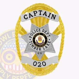 This custom metal badge in gold features a distinctive star shape with elegant silver accents. The word "CAPTAIN" is prominently displayed at the top in bold black letters. In the center, the badge showcases the Timber Lake Police Department emblem, surrounded by "STATE OF COLORADO" and "POLICE DEPT." A safety pin attachment ensures secure wearing.