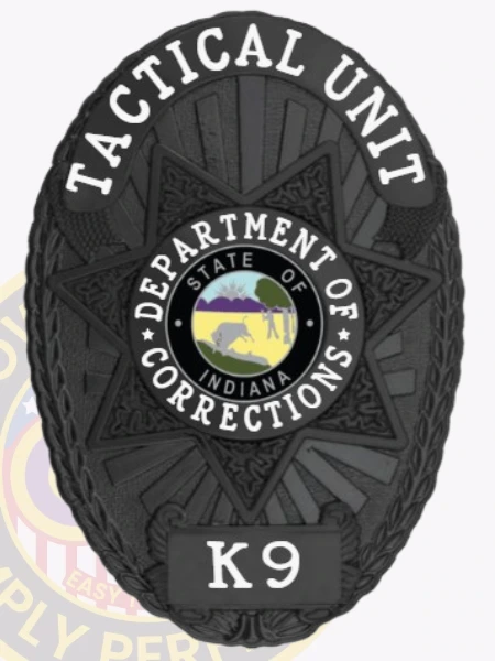 Custom metal badge in black with safety pin attachment, designed for the Tactical Unit in the Indiana Department of Corrections. The badge features the text "TACTICAL UNIT" prominently at the top, with a central state emblem encircled by "DEPARTMENT OF CORRECTIONS." The star-shaped design is highlighted by intricate textures, enhancing its authoritative look. The badge includes a "K9" designation at the bottom, indicating its specialized function. The safety pin attachment ensures secure fastening to uniforms, providing both practicality and visibility for law enforcement personnel.