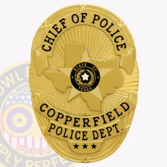 Gold-colored oval metal badge made for copperfield police chief, featuring the texas state shape with star emblem in the center marked "state of texas," black lettering reading "chief of police" above and "copperfield police dept. " below, finished with three stars near the bottom, equipped with safety pin attachment.