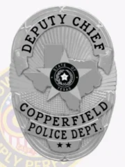 Oval silver metal badge for Copperfield Police Department Deputy Chief, displaying Texas shape in the middle with a central star and "STATE OF TEXAS" circle, bold black text "DEPUTY CHIEF" at the top and "COPPERFIELD POLICE DEPT." below, featuring two stars at the bottom and a safety pin fastening.