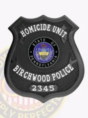 Custom Birchwood police homicide unit badge in black metal shield form with a safety pin attachment, showing HOMICIDE UNIT prominently on a curved white banner at the top, a detailed State of Pennsylvania seal in the middle, BIRCHWOOD POLICE below it, and 2345 near the bottom.