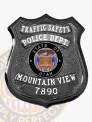 Detailed custom black metal shield badge for Mountain View police traffic safety unit with safety pin fastener, featuring TRAFFIC SAFETY boldly printed on a curved white banner at the top, POLICE DEPT. underneath, a round State of Utah seal emblem in the middle, and MOUNTAIN VIEW 7890 displayed clearly near the base.