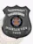 Detailed custom black metal shield badge for Mountain View police traffic safety unit with safety pin fastener, featuring TRAFFIC SAFETY boldly printed on a curved white banner at the top, POLICE DEPT. underneath, a round State of Utah seal emblem in the middle, and MOUNTAIN VIEW 7890 displayed clearly near the base.