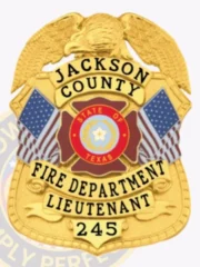 This eye-catching custom metal badge in gold color offers a safety pin attachment for easy fastening. It displays "JACKSON COUNTY FIRE DEPARTMENT LIEUTENANT 245" and features the Texas state emblem and flags, honoring the bravery of fire service professionals.