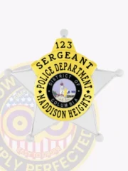Five-point star silver metal badge with gold panels for Madison Heights Police Sergeant, showing bold black text on a yellow circular banner around the District of Columbia seal, attached with safety pin.