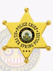 Polished gold 6 point star badge for Silver Spring Police Chief, featuring six rounded points topped with balls, a detailed North Dakota state seal at the center, black text encircling it stating "POLICE CHIEF SILVER SPRING POLICE," and a safety pin backing.