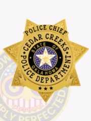 Cedar Creeks Police Chief custom gold 7 point star metal badge showing embossed floral designs on each point, a blue circular emblem with the Oklahoma state seal centered by a white star, clear black lettering around it, and three stars on a gold scroll at the bottom, attached by safety pin.