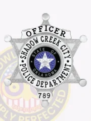 Custom 6 point star police badge in silver metal for Shadow Creek City Police Officer, featuring bold black text on a white arched plate reading “OFFICER,” the official Oklahoma emblem in the center surrounded by department name and badge number “789,” with a safety pin attachment.