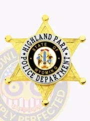 Polished gold 6 point star metal badge for Highland Park police, featuring a detailed star design and a center medallion with the Wyoming state seal, surrounded by white and black text reading "POLICE DEPARTMENT" and "HIGHLAND PARK," with a safety pin attachment.
