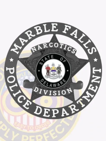 Bold black custom badge with a five-point star encased within a circle banner stating "Marble Falls Police Department," featuring a banner across the star labeled "Narcotics Division," and the State of Delaware seal in the middle, made for safety pin attachment.
