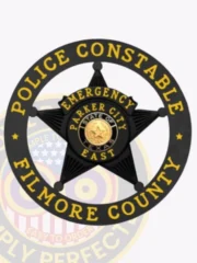 This striking custom metal badge in black color features a prominent star design at the center, surrounded by a circular border that reads "POLICE CONSTABLE" at the top and "FILMORE COUNTY" at the bottom. The badge highlights "EMERGENCY," "PARKER CITY," and "EAST," along with the state emblem of Texas, designed with a safety pin attachment for secure wear.