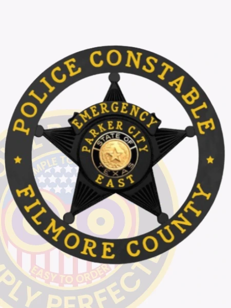 This striking custom metal badge in black color features a prominent star design at the center, surrounded by a circular border that reads "POLICE CONSTABLE" at the top and "FILMORE COUNTY" at the bottom. The badge highlights "EMERGENCY," "PARKER CITY," and "EAST," along with the state emblem of Texas, designed with a safety pin attachment for secure wear.