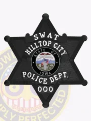 Black metal six-point star badge designed for Hilltop City police SWAT unit, displaying bold white lettering on the star points and center, including the words "SWAT," "HILLTOP CITY," and "POLICE DEPT.," encircling a detailed Iowa state emblem, equipped with a safety pin fastener.