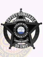Custom metal badge in black color with safety pin attachment, featuring a star design. The badge displays the words "DEPUTY CONSTABLE" and "EMERGENCY" prominently at the top. In the center, it showcases "DORRIS BEND, STATE OF TENNESSEE" along with "VERNON LAKE," surrounded by a circular emblem. The bottom includes "LONDON COUNTY" and the number "59 UNIT," emphasizing its official capacity and importance for law enforcement.