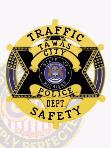 Tawas City Police Traffic Safety badge in black metal shaped as a six-point star, with a gold circle banner reading "Traffic Safety," the Michigan state seal in the middle, and secured with a safety pin.