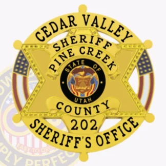 A close-up of a custom metal badge in a bright gold color, designed in the shape of a star, representing the Cedar Valley Sheriff's Office. The badge features the text "CEDAR VALLEY," "SHERIFF," and "PINE CREEK" prominently on the top, with "COUNTY 202" and "SHERIFF'S OFFICE" at the bottom. The center showcases the state seal of Utah, surrounded by decorative elements. It includes a safety pin attachment on the back, ensuring secure fastening for easy wear by law enforcement personnel.